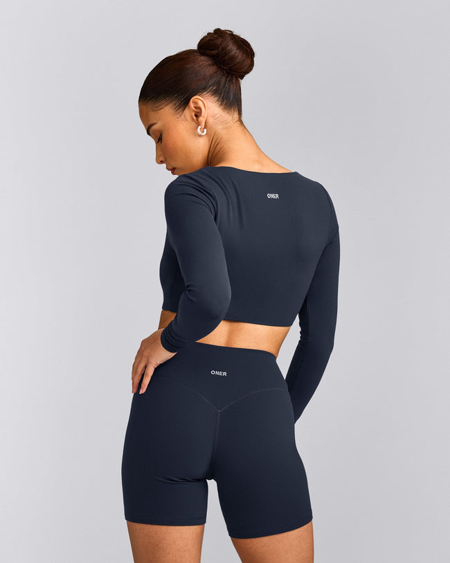 SoftMotion™ Scoop Neck Long Sleeve Crop Top with Built in Bra Shelf with Grey Logo | True Blue