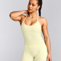 EnhanceLift™ Seamless Strappy Racer Tank Top with Built in Bra Shelf with Gray Logo | Pastel Yellow