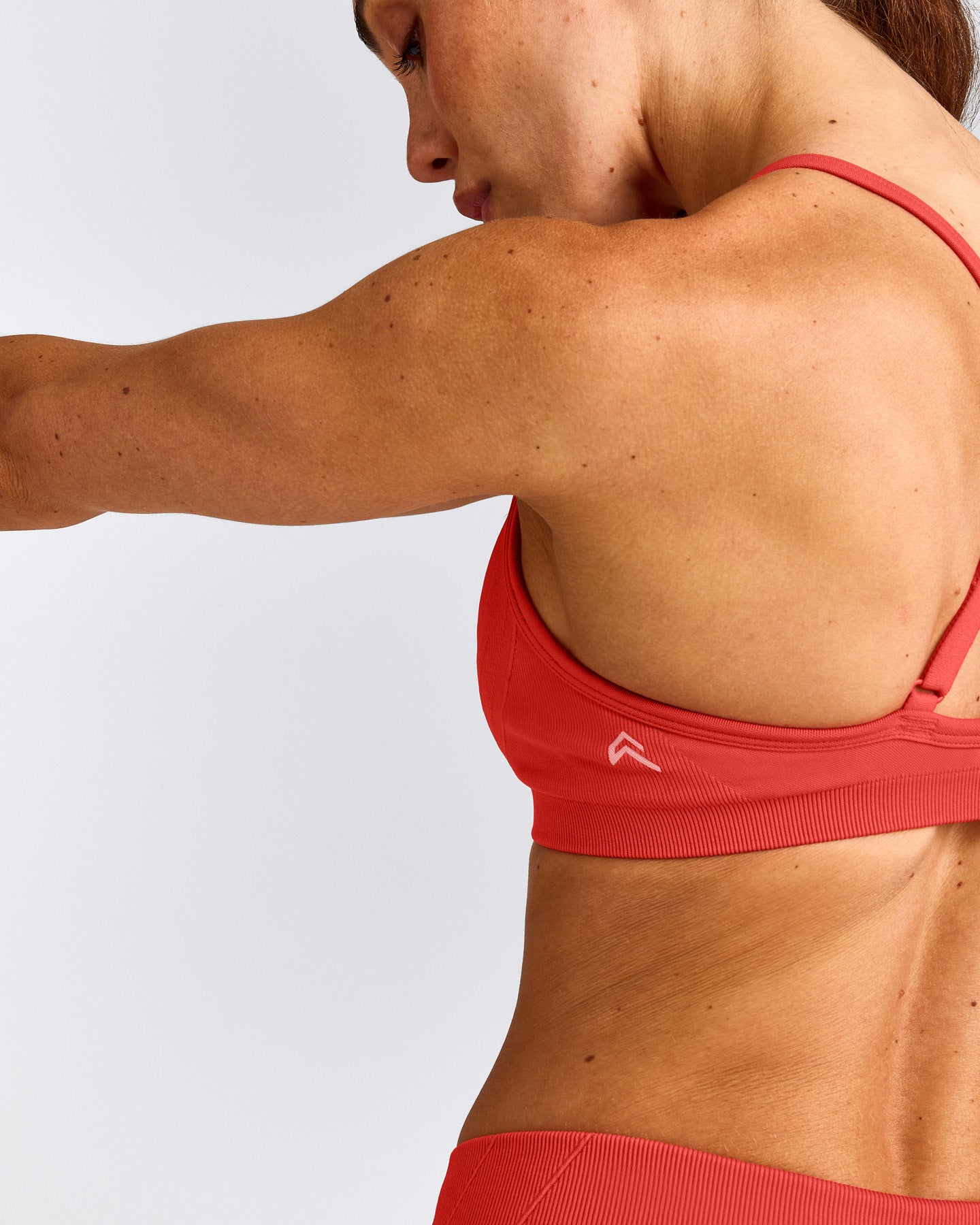 EnhanceLift™ Seamless Strappy Sports Bra with Gray Logo | Dark Charged Coral
